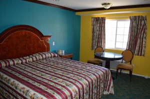 a bedroom with a bed and a table and a window at Cloud 9 Inn LAX in Inglewood