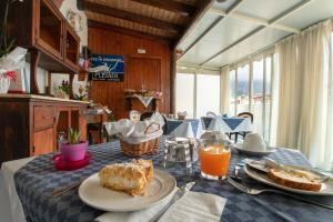 un tavolo con un piatto di cibo e succo d'arancia di B&B Pleiadi a San Vito lo Capo Altre 18 foto