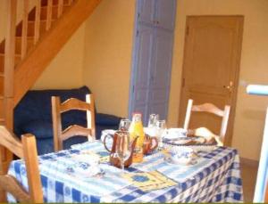 La Vallée des Trois Monts في Saint-Sylvestre-Cappel: طاولة مع قطعة قماش منضدة زرقاء وبيضاء