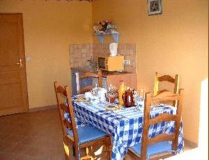 een eettafel met een blauw en wit geruit tafelkleed bij La Vallée des Trois Monts in Saint-Sylvestre-Cappel