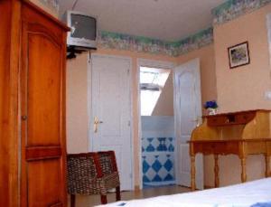 a room with a bedroom with a bed and a piano at La Vallée des Trois Monts in Saint-Sylvestre-Cappel