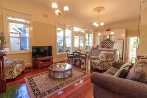 a living room with a couch and a tv at The Oaks Lilydale Accommodation in Lilydale