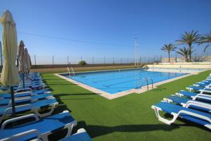 una gran piscina con tumbonas y sombrillas en CasaTuris Albufera playa A111, en Alicante