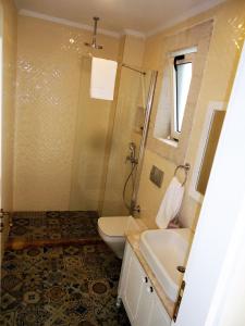 a bathroom with a shower and a toilet and a sink at Grand Alaçatı Butik Hotel in Alaçatı