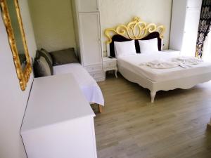 a bedroom with two beds and a mirror at Grand Alaçatı Butik Hotel in Alaçatı