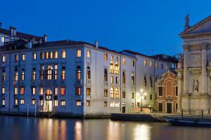 ヴェネツィアにあるホテル パラッツォ ジョヴァネッリ エ グラン カナルの夜の水辺の大きな建物