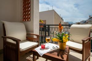 un balcone con due sedie e un tavolo con un bicchiere di vino di B&B Pleiadi a San Vito lo Capo