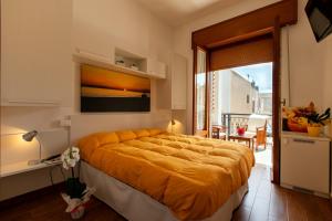 サン・ヴィート・ロ・カーポにあるB&B Pleiadiのベッドルーム1室(大型ベッド1台、オレンジの毛布付)