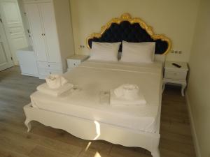 a bedroom with a bed with two towels on it at Grand Alaçatı Butik Hotel in Alaçatı