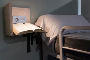 a bed that has a book on top of it at Albergue Goas in Abadín