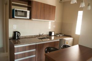 a small kitchen with a sink and a microwave at Ivy in Resistencia