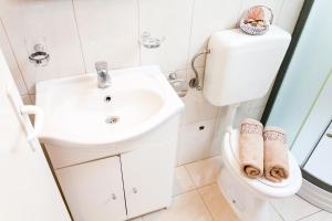 Baño blanco con aseo y lavamanos en Guest House Mara, en Vela Luka