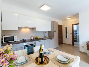 a kitchen and dining room with a table with a bottle of wine at Apartments Gioia in Poreč