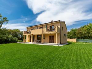 ein Haus mit großem Rasen davor in der Unterkunft Apartments Gioia in Poreč