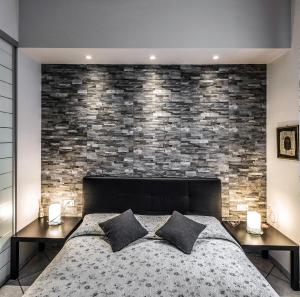Un dormitorio con una pared de ladrillo y una cama en Lia Apartment 2, en La Spezia