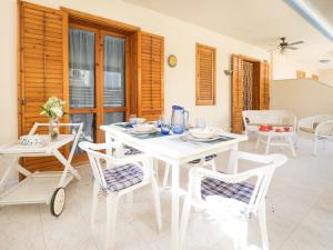 una sala da pranzo bianca con tavolo e sedie bianchi di siciliacasevacanze - Casa Girasole a Marina di Ragusa