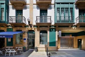 a building with tables and chairs on a street at Hotel Santa Rosa, Blue Hoteles in Gijón
