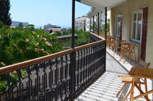 Un balcón con mesas y sillas en un edificio en Guest House Edem, en Sudak