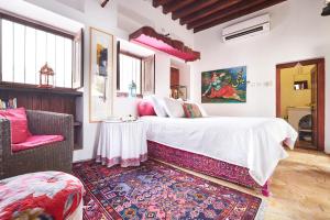 a bedroom with a bed and a chair and a rug at XVA Art Hotel in Dubai