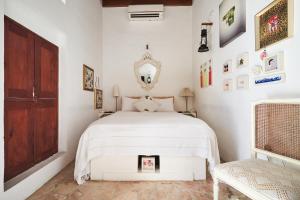 a bedroom with a white bed and a mirror at XVA Art Hotel in Dubai