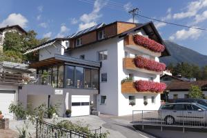 a white house with a car parked in front of it at Pension Waldesruh in Tarrenz