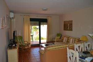 sala de estar con sofá, mesa y sillas en Bajo Con Vistas Al Mar en Zahara de los Atunes