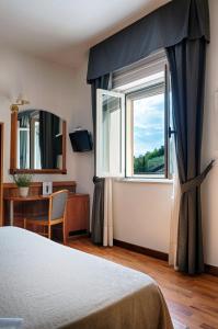 a bedroom with a bed and a window and a desk at Casa Ferretti di Ferretti Village in Silvi Marina