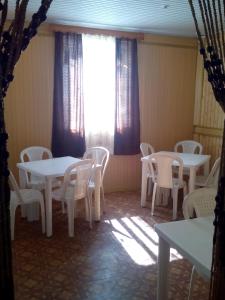 a room with white tables and chairs and a window at Guest House Giorgi in Ureki