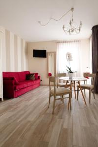 a living room with a red couch and a table at Villa Poggio Bardolino in Bardolino