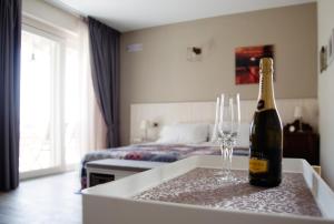 a bottle of champagne and two glasses on a table in a room at Villa Poggio Bardolino in Bardolino