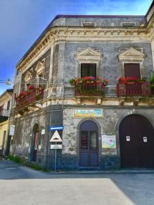 an old building with flower boxes on the windows at B&B Da Rosa in Linguaglossa