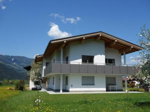 a white house with a balcony on the side at Apart Haun in Stumm