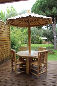 een tafel en stoelen onder een paraplu op een terras bij Résidence les Caraibes in Sérignan
