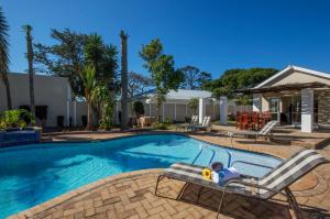 a child sitting in a chair next to a swimming pool at Walmer Villiers Self Catering in Port Elizabeth