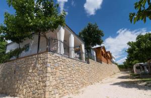 Una pared de piedra con una casa. en Odmoree Camp & Hostel, en Ražanac