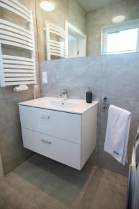 ウストロニエ・モルスキエにあるKap Ustronie Morskie - 365PAMのバスルーム(白い洗面台、鏡付)