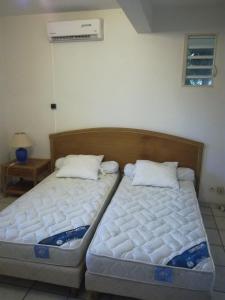 two beds sitting next to each other in a room at Marcus972 in Sainte-Luce