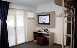 Televízia a/alebo spoločenská miestnosť v ubytovaní Hotel Carnia