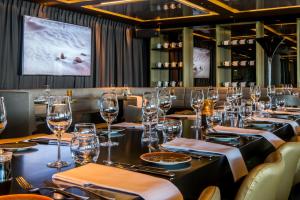 een eetkamer met een lange tafel met wijnglazen bij Fletcher Hotel-Restaurant Arion-Vlissingen in Vlissingen