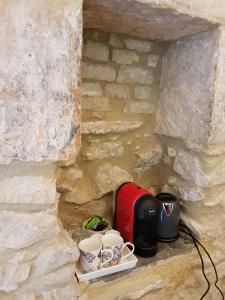 een hoek van een stenen muur met koffiepotten en kopjes bij Casa Santa Maria - Fichi d'india in Ragusa