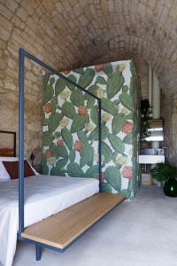 een slaapkamer met een bed met een bloemenmuur bij Casa Santa Maria - Fichi d'india in Ragusa