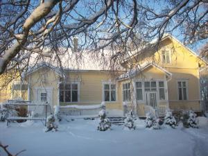 a yellow house with snow on the front of it at Brinkin Wanha Pappila in Kokkola