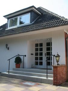 ein Haus mit einer Veranda und einem Fenster darüber in der Unterkunft Nordsee Domizil Schobüll in Husum