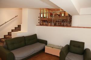 a living room with a couch and a staircase at Pensiunea Mihaela in Poiana Brasov