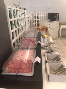 un bancone con molti vassoi di carne sopra di Hotel Smeraldo a Brenzone sul Garda