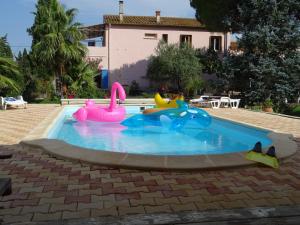 una piscina con tres juguetes inflables. en Gite Mas Des Ecureuils, en Palau-del-Vidre