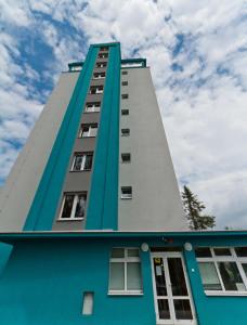 wysoki, niebiesko-biały budynek z oknami w obiekcie Hotelak Martinov w Ostravie