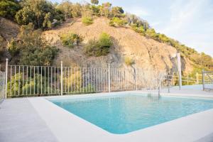 a swimming pool in front of a mountain at Hotel Eliseos in Málaga