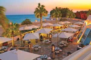 una vista panoramica su una spiaggia con tavoli e ombrelloni di Sunset Beach Resort Marina & Spa a Al Khobar