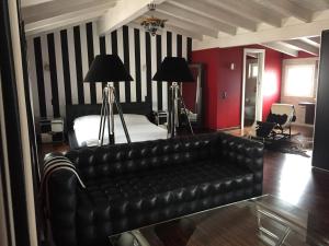 Le Suites al Lago في ميليده: غرفة معيشة مع أريكة جلدية وسرير